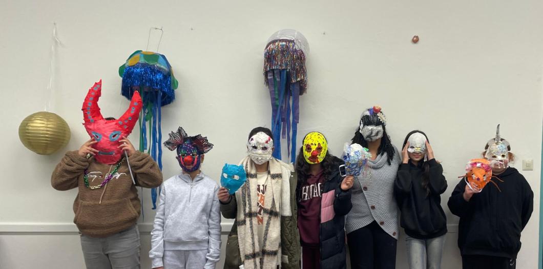Die Kinder haben Masken auf ihrem Gesicht, die sie selber gebaut und gestaltet haben.