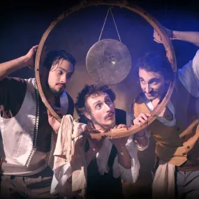Die drei Schauspieler vom Kabinet Mirage schauen erwartungsvoll durch einen Holzreifen