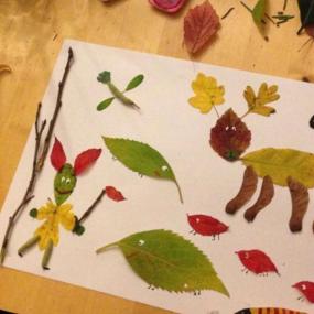 Tiere und Lebewesen aus Laub wurden auf Papier geklebt. Sie wurden mit augen versehen. 