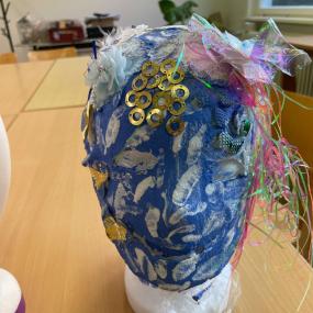 Eine blaue Maske mit goldenen und schimmernden Verzierungen. 