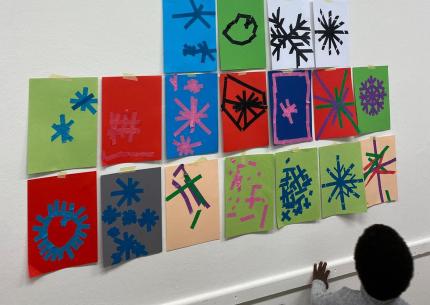 Kita-Kinder haben Schneeflocken aus Klebeband in verschiedenen Farben gestaltet.