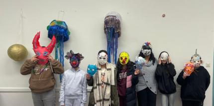 Die Kinder haben Masken auf ihrem Gesicht, die sie selber gebaut und gestaltet haben.